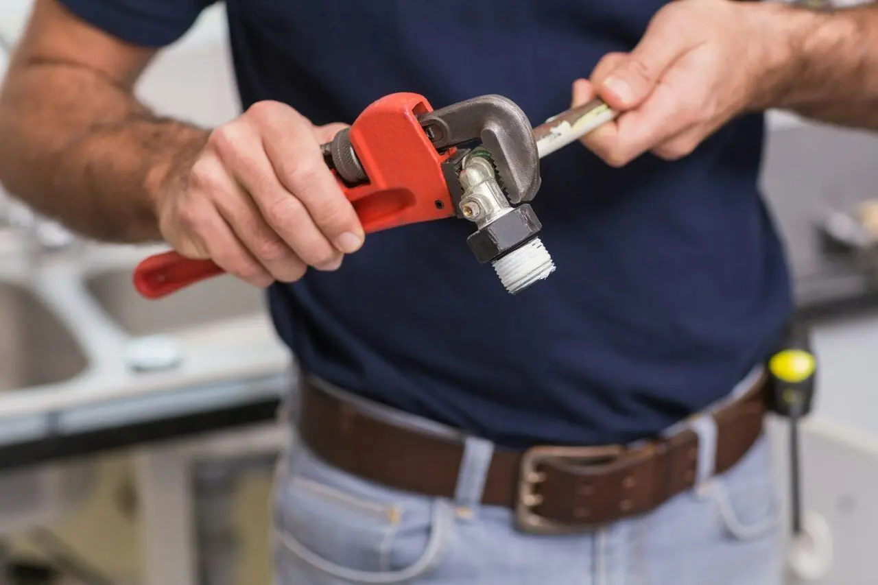 Emergency kitchen pipe repair by PAGE Tradie's licensed Sunshine Coast plumber using professional wrench